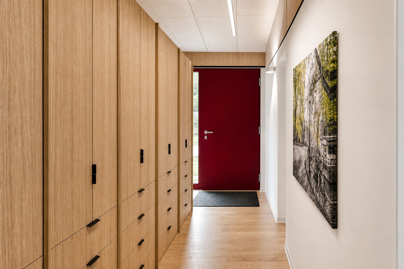 Eingangsbereich mit raumhohem Holz-Einbauschrank und roter Haustür